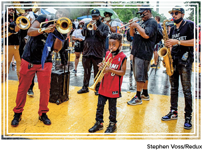 A young boy plays trumpet with a band at a Juneteenth march in Washington, D.C., in 2020.