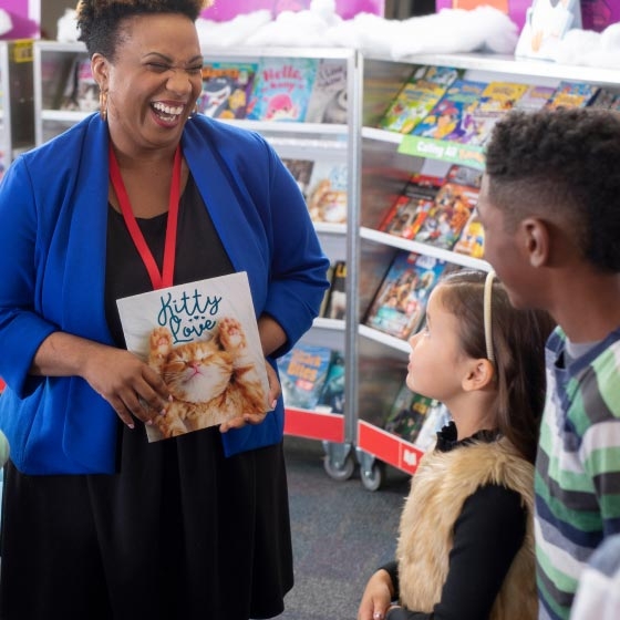 Teacher and students in front of a book case