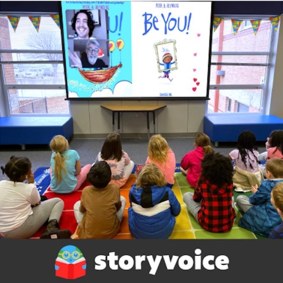 A group of students sitting on the floor attending a Storyvoice event in their classroom with the storyvoice logo imposed on the bottom of the image 